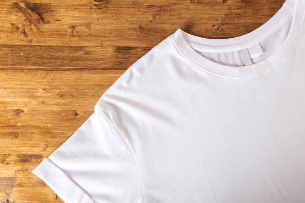 istock White t-shirt on a wooden background - Image 1140068820
