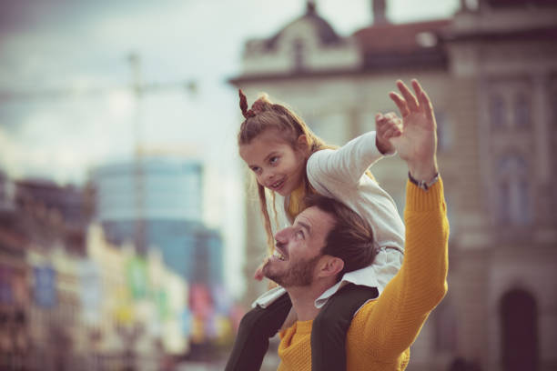 Father and daughter having fun in a park on a cold autumn day.