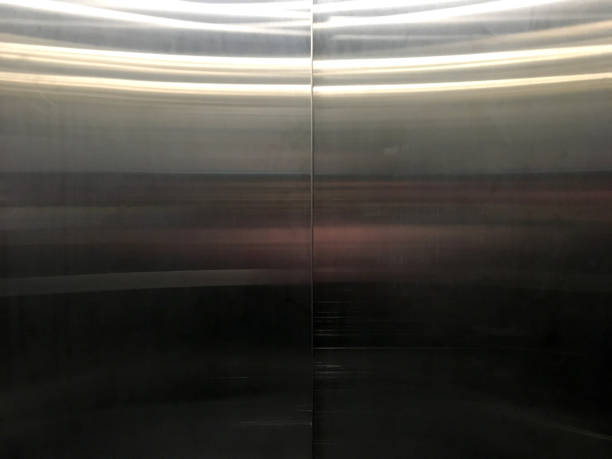 темные блестящие серебряные двери лифта крупным планом с отражением освещения фона. - glister стоковые фото и изображения