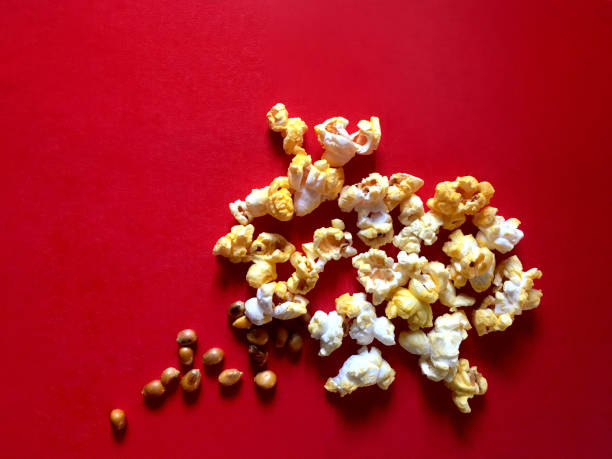 istock Popcorn and raw seed with cheese and butter flavor on red background. 1140074265