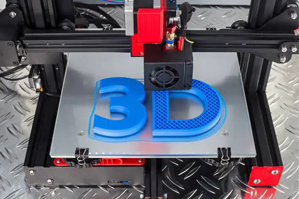 Photo of Red black 3D printer printing blue logo symbol on metal diamond plate future technology modern concept