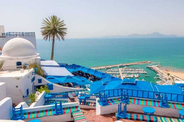 Beautiful view over seaside at white blue village of Sidi Bou Said Named for a religious figure who lived there, Abu Said al-Baji, it was previously called Jabal el-Menar. The town itself is a tourist attraction and is known for its extensive use of blue and white. tunisia beach stock pictures, royalty-free photos & images