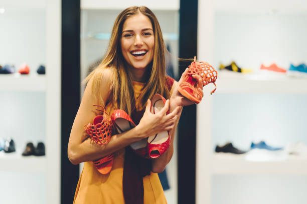 Woman enjoying the day in the shopping mall Happy woman in the shop holding a pile of shoes women shoes stock pictures, royalty-free photos & images
