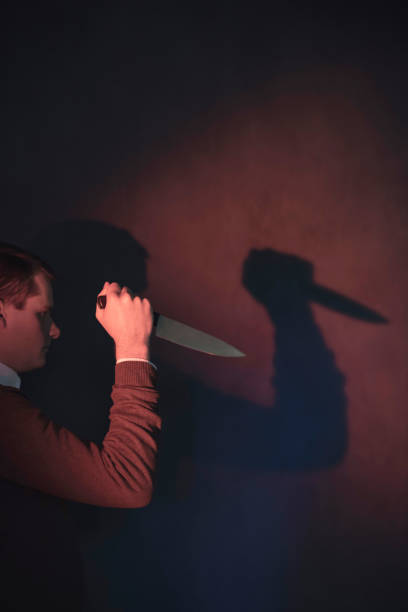istock Young man in brown sweater holding knife. 1140077910