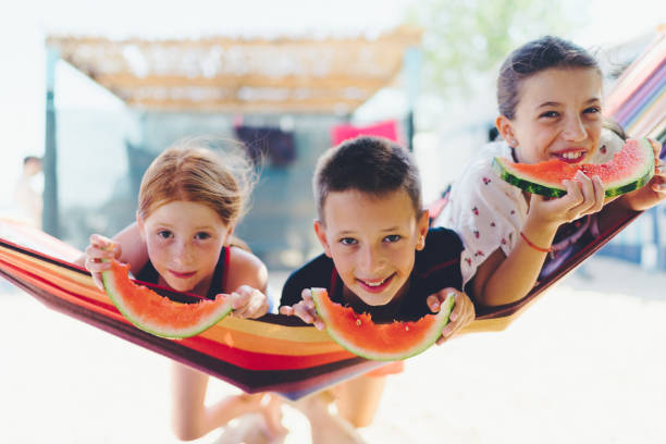 istock Kids in hammock eating watermelon 1140083404
