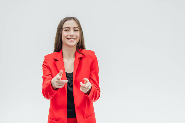 istock Young good girl business is worth it. Shows with two hands forward. During this, the index finger shows directly. Dressed in a red jacket. 1140092345