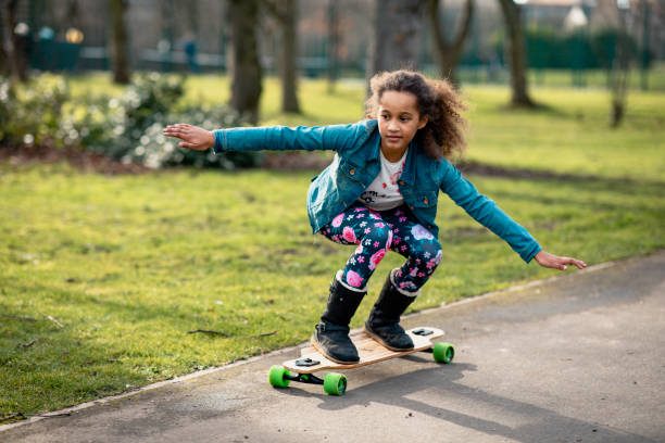 Skateboard Skills Girl skateboarding down a path in a public park. skateboard stock pictures, royalty-free photos & images