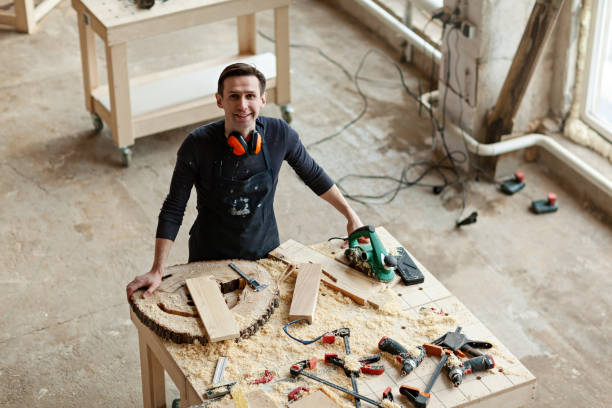 istock From above view of young smiling woodworker looking at camera at workbench covered with tools wood pieces and sawdust 1140094764