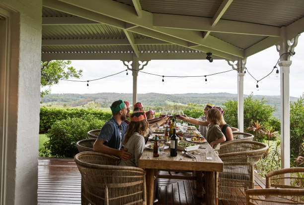 Coming together with good food and wine Cropped shot of a family having Christmas lunch together in their backyard traditionally australian stock pictures, royalty-free photos & images