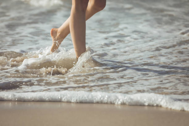 istock Woman walking along the ocean at the beach 1140096177