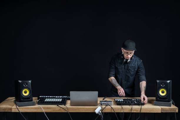 istock Adult and concentrated DJ master. Man using controller and records music inside house room studio with black dark wall interior and copy empty space for text 1140096268
