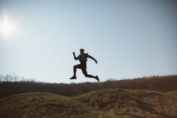 istock Man running in a park or forest against trees background. 1140096883