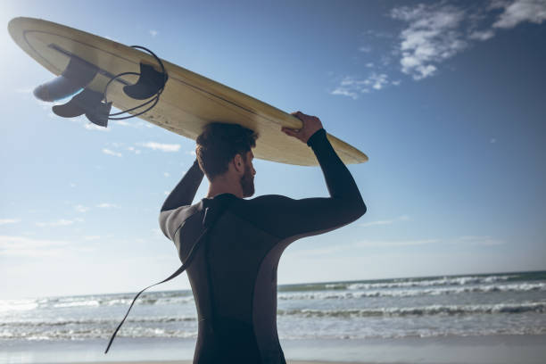 istock Male surfer holding surfboard at beach 1140098016