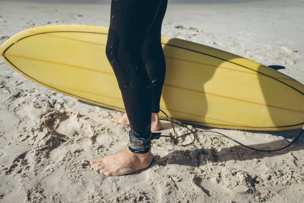 istock Male surfer standing on sand at beach 1140098053