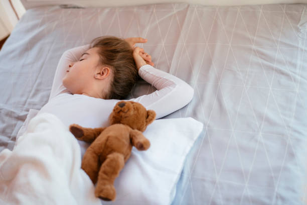 istock Little girl sleeping with teddy bear 1140098871