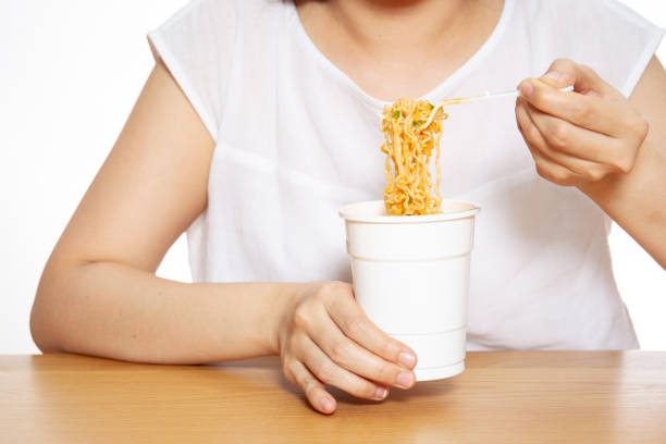 istock Hungry woman eating a noodle cup. 1140099944