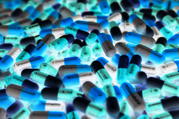 Pile of blue, green, and white color of capsule pills with modern design light. Toxicology medicine concept. QC and QA in pharmaceutical industry background. Global healthcare. Pile of blue, green, and white color of capsule pills with modern design light. Toxicology medicine concept. QC and QA in pharmaceutical industry background. Global healthcare. antibiotic resistant photos stock pictures, royalty-free photos & images