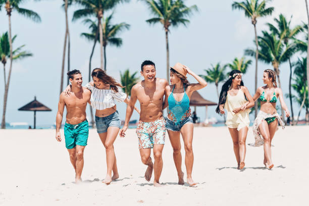 istock Multi-ethnic group of young people walking on the beach 1140100173