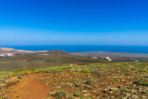 istock Spain, Lanzarote, Blue atlantic ocean water behind endless fields of cactus and winegrowing near ye 1140100335