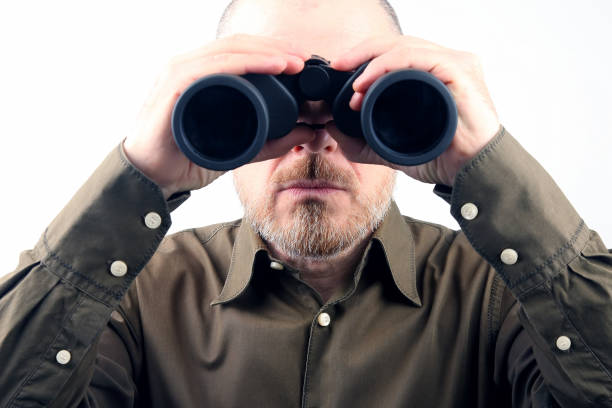 istock Bearded man looking through binoculars into the distance 1140101069