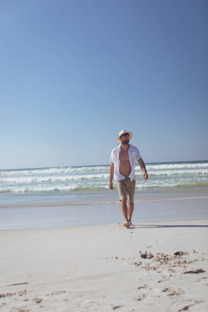 istock Man walking at beach on a sunny day 1140101232