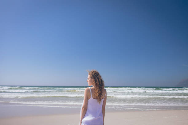 istock Young woman standing at beach on a sunny day 1140101724