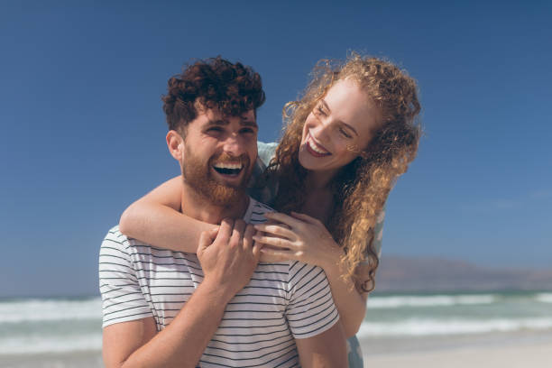istock Happy couple interacting with each other at beach on a sunny day 1140101959