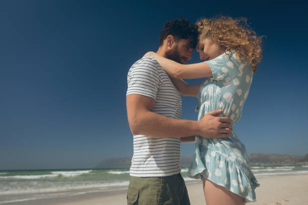 istock Young couple standing at beach on a sunny day 1140102036