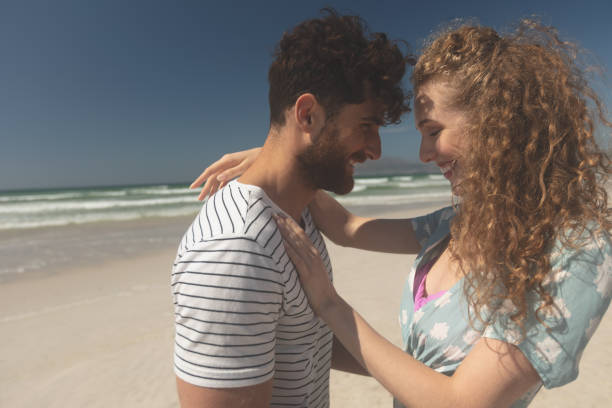 istock Happy couple standing at beach on a sunny day 1140102058