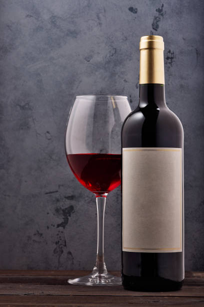 istock red wine and grapes. Wine and grapes in vintage setting with corks on wooden table 1140103315