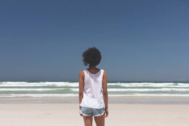 istock Beautiful woman standing at beach on a sunny day 1140104297
