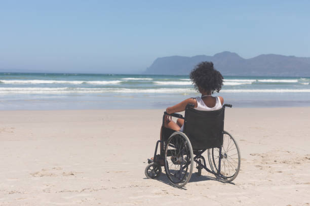 istock Young woman disable sitting on wheelchair at beach 1140104559