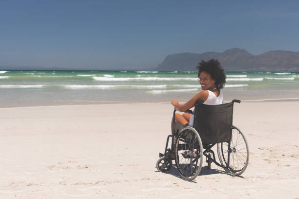 istock Young woman disable sitting on wheelchair at beach 1140104574