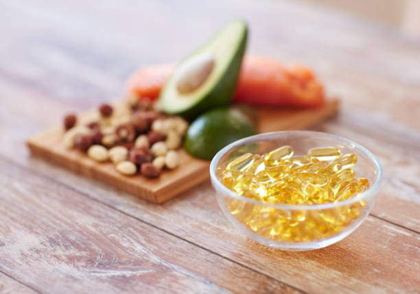 close up of omega 3 capsules and food on table - fish oil vegetable capsule healthy eating imagens e fotografias de stock