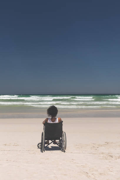 istock Young woman disable sitting on wheelchair at beach 1140105791