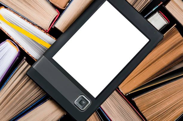 istock The e-book with a white screen lies on the open multi-colored books that lie on a dark background, close-up 1140105893