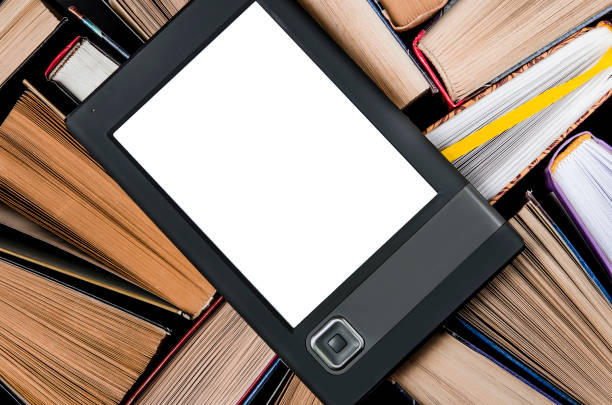 istock The e-book with a white screen lies on the open multi-colored books that lie on a dark background, close-up 1140105895