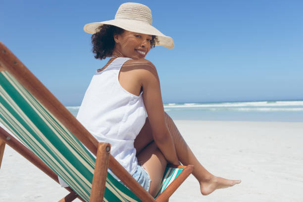 istock Young woman giving pose while sitting on sun lounger at beach 1140105991