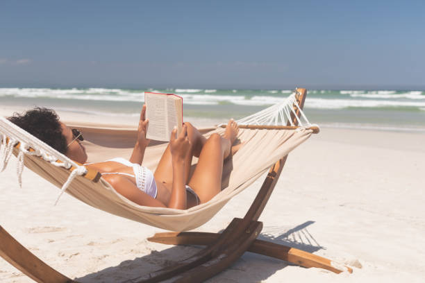 istock Woman relaxing on hammock at beach on a sunny day 1140106683