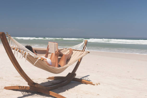istock Woman relaxing on hammock at beach on a sunny day 1140106734