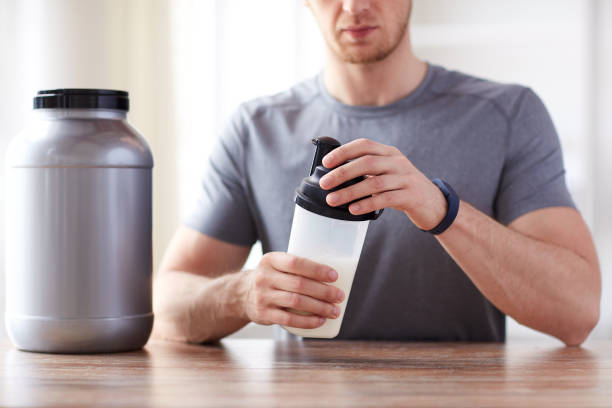 istock close up of man with protein shake bottle and jar 1140109370