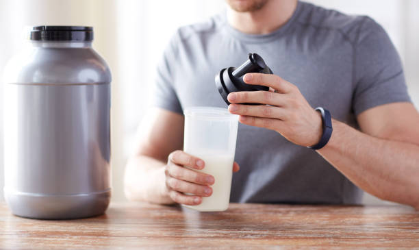 istock close up of man with protein shake bottle and jar 1140109576