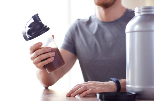 istock close up of man with protein shake bottle and jar 1140109596