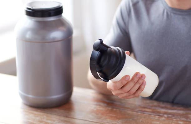 istock close up of man with protein shake bottle and jar 1140109800