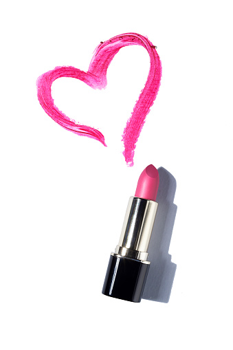 Creative concept valentine photo of cosmetics swatches beauty products lipstick with heart on white background.