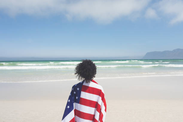 istock Woman wrapped american flag at beach 1140111306