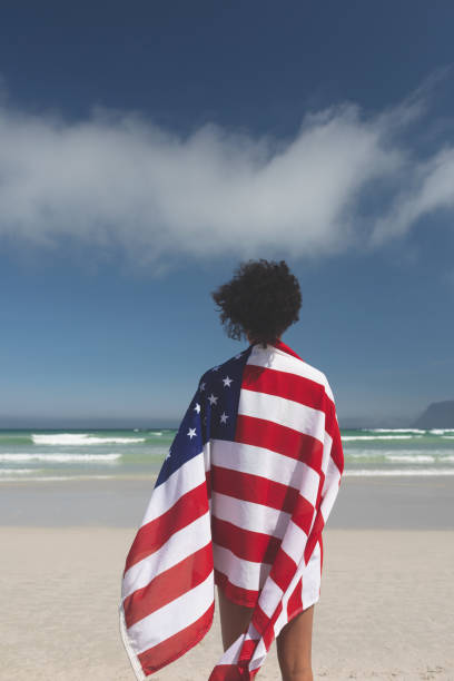 istock Woman wrapped american flag at beach 1140111325