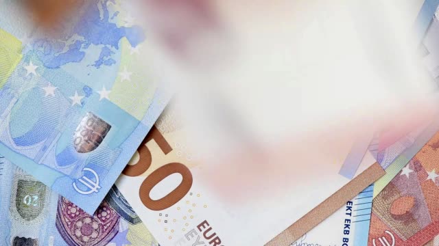 many Euro banknotes flying