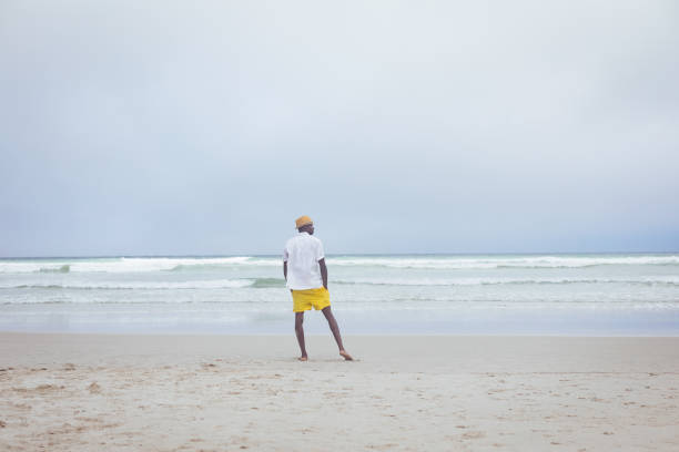 istock Man standing at beach on a sunny day 1140111792