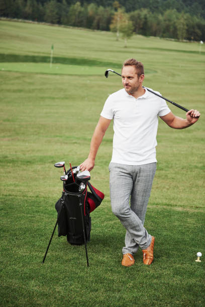 istock A professional player stands on a golf course, holds a metal bag and a golf bag 1140115135
